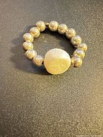 Full view of elastic ring with silver beads and frosted white centerpiece