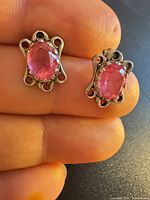Front view of both sterling silver stud earrings showing pink stones and decorative settings