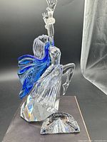 Full view of Swarovski Isadora figurine showing raised arms, blue scarf, and faceted base