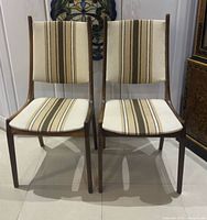 front view of both teak chairs showing upholstery pattern and frame