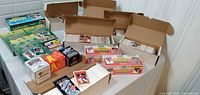 Multiple open long cardboard boxes filled with hockey trading cards and three unopened packs on table