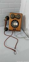 Front view showing wood case, bells, rotary dial, handset and cords