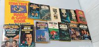 All 14 Star Trek paperbacks and game book laid out