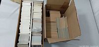Two open cardboard boxes filled with sorted stacks of hockey trading cards