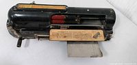 Full view of Protectograph check writer showing body, lever, ink rollers, instruction plate and check platform