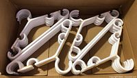 Box containing multiple elastic-bundled white baby hangers