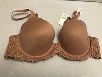 Front view of bra showcasing molded cups, lace wings, tag visible