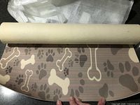 Rolled mat partially unrolled showing paw and bone design