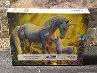 Front of sealed puzzle box showing unicorn artwork and details such as 200 pieces and 48 × 33 cm size
