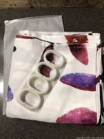 Folded shower curtain, separate pack of white hooks, zip pouch