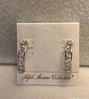 Front view of hoop earrings on branded card showing cubic zirconia stones