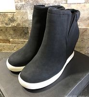 Pair of black Kenneth Cole Kam wedge boots angled view