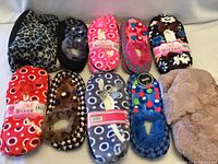 All ten pairs of assorted plush slippers laid out