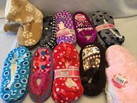 Group shot of all ten pairs of slippers showing colours and packaging