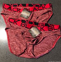 Two heathered red Andrew Christian Black Collection briefs with tags displayed