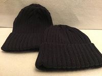 Two black rib-knit toques side by side