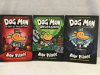 Front covers of three Dog Man hardcover books