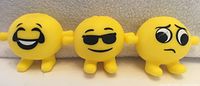 Three yellow emoji stress balls with different facial expressions