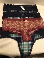 Stack of five underwear showing colours, lace detail, tags attached