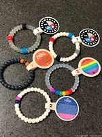Six bracelets with tags displayed on countertop