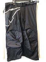 Front view of black Mission RH Inhaler AC4 pant showing logo, mesh knee panels, adjustable waist