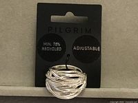 Front view of Pilgrim adjustable silver-tone wire wrap ring on branded card