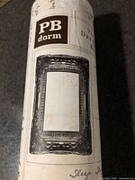 Packaging showing PB dorm branding and illustration of framed decal