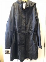 Full view of black hooded spring coat hanging