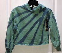 Front view of green/blue tie-dye cropped hoodie with tag attached