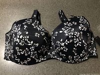 Front view of black and white floral padded underwire bra with tags visible
