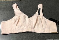 Front view of light peach VoGlo wireless bra showing cups, band, tags