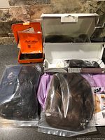 Countertop layout of boxed and bagged hair pieces with accessories