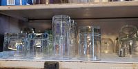Shelf with multiple clear glass tumblers inverted