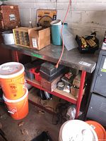 Overall lot on metal table showing parts organizer, fasteners, toolboxes and buckets
