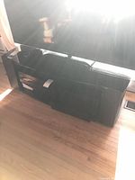 Front view of black TV stand beneath television