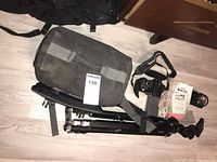 Overall lot showing camera body, strap, manuals, bag and tripod