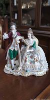 Full view of both porcelain figurines on scroll base