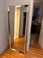 Full view of floor mirror leaning against wall