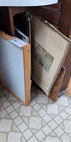 Wood-framed dry-erase board, framed botanical print and additional board stored upright