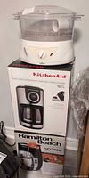 Salton steamer placed atop boxed KitchenAid and Hamilton Beach coffee makers