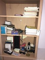 Full bookshelf view with notebooks, books, CD cases, small items