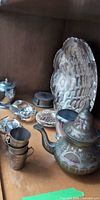 Group view of teapot, cups, lidded sugar, coasters, tray, paperweights