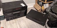 Three stacked Onkyo components (tuner, cassette deck, amplifier) and separate Pioneer CD player on floor