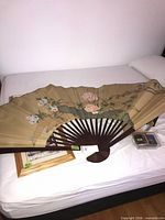 Full view of oversized folding wall fan on bed