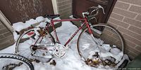 Full view of Peugeot Super Sport bicycle leaning against wall in snow