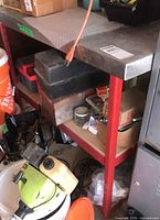 Full view of table top, legs, and shelf with surrounding items