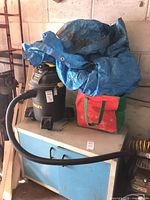 Vacuum sitting on cabinet with hose attached