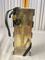 Front view of boxed Argento SC gold glitter pen with ribbon and tag visible