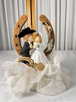 Front view of topper showing figurine, horseshoe, jute rope, boot charm and tulle base