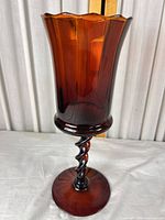 Full view of amber glass vase showing scalloped rim, fluted bowl, twisted stem, round foot